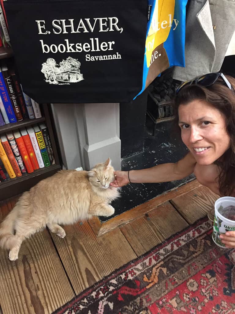 Donna petting an orange tabby cat at a bookstore in South Carolina.