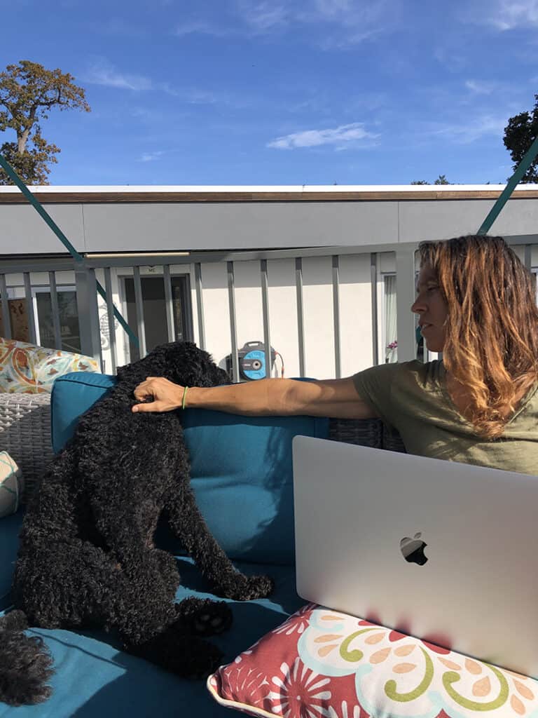 A picture of Donna and Piper sitting on the roof top patio enjoying the weather while Donna works.