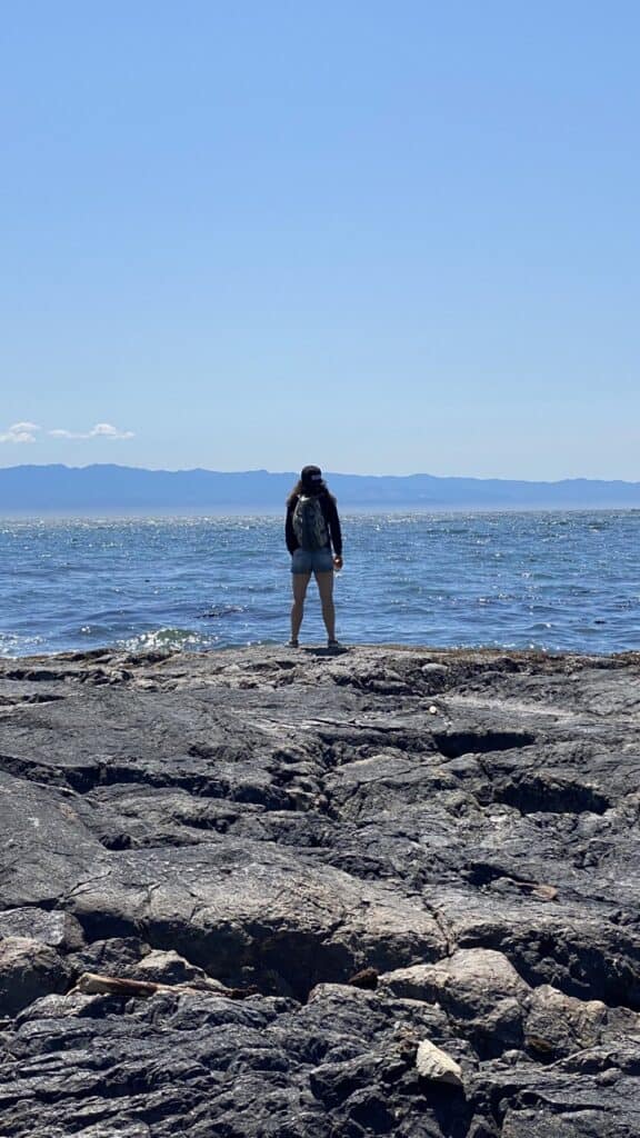 A picture of Donna from behind looking out into the ocean in Victoria, BC.