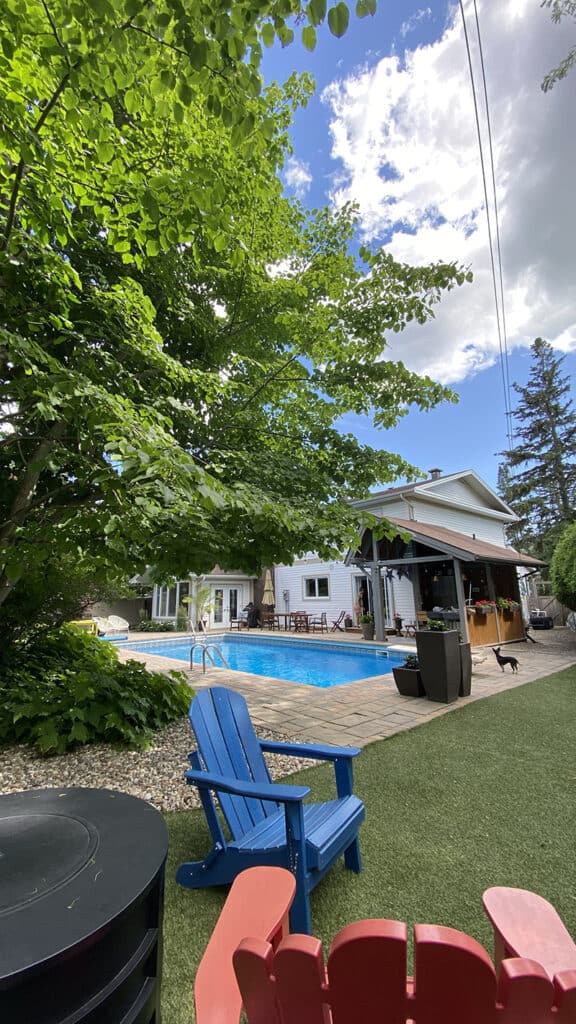 A picture from the corner of a backyard of a house sit we did. You can see the chairs, turf, and pool in the background. This Trusted Housesitters review highlights the great homes you can stay in.