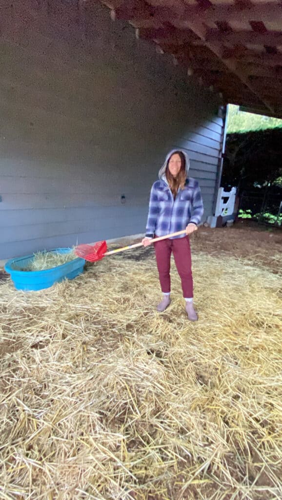 A picture of Donna scooping poop on the farm.